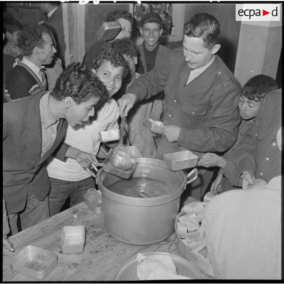 Le capitaine Ranchoux distribue la soupe aux enfants.