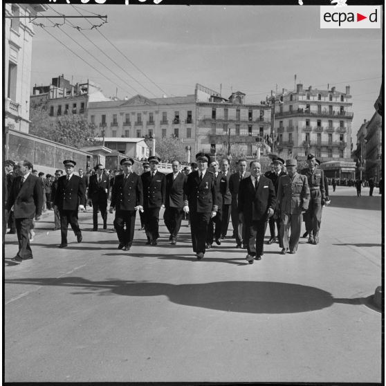 Robert Lacoste, le général Robert Loth et Maurice Papon, descendent à pied l'avenue Liagre.