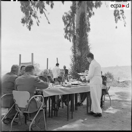 Le général Raoul Salan déjeune avec des autorités.