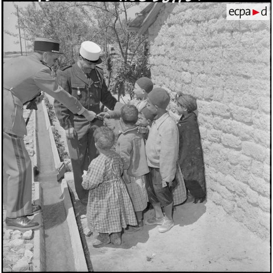 Le colonel Legay distribue des gâteaux aux enfants de la harka.