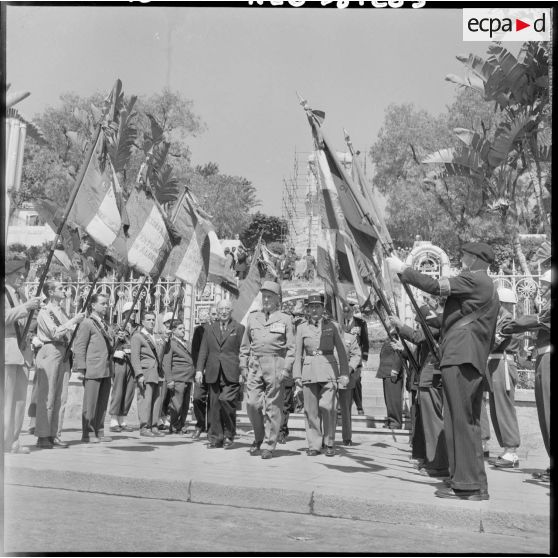 Le général Raoul Salan quitte le monument et passe sous les drapeaux de la Légion. Ceux-ci sont présentés par des anciens de cette arme.
