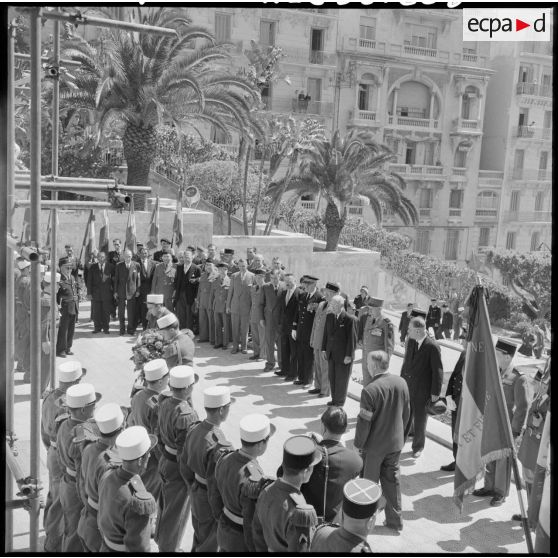 Deux légionnaires déposent une gerbe de fleurs au pied de la stèle.