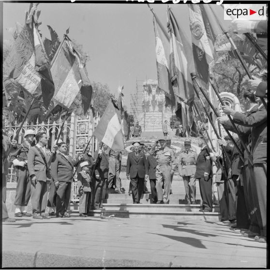 Le général Raoul Salan quitte le monument et passe sous les drapeaux de la Légion. Ceux-ci sont présentés par des anciens de cette arme.