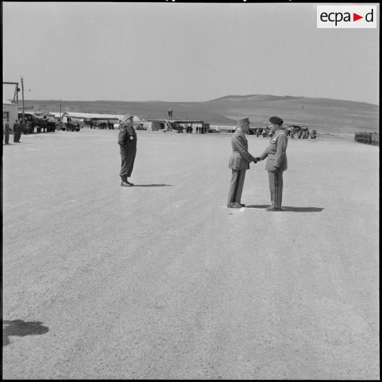 Passation de commandement : les généraux Robert Loth et Jean Gilles se serrent la main sous le regard de Paul Vanuxem.