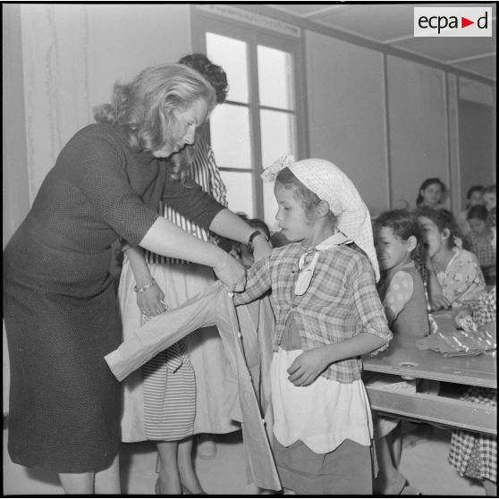 Quelques jeunes filles de l'antenne médico-sociale (AMS) de Douera procèdent à la distribution de vêtements aux enfants.
