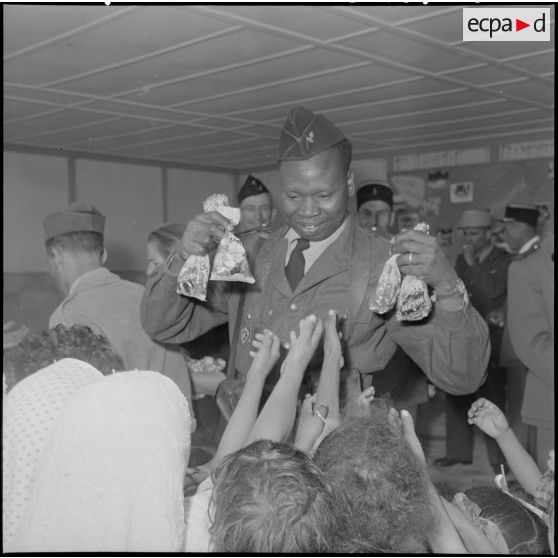 Un soldat de Saint Louis du Sénégal, distribue des friandises.