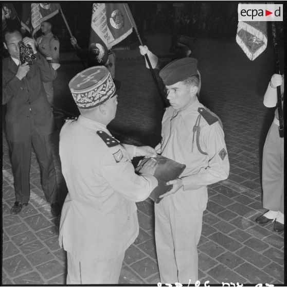 Une autorité militaire remet des décorations sur le coussin des décorations.