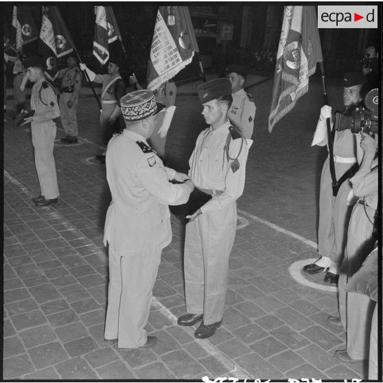 Une autorité militaire remet des décorations sur le coussin des décorations.