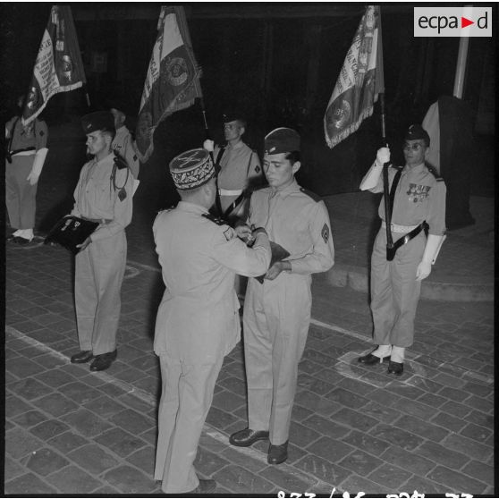 Une autorité militaire remet des décorations sur le coussin des décorations.