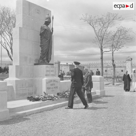 Remise d'une gerbe de fleurs au monument aux morts.