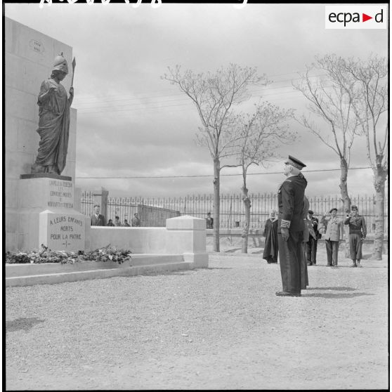 Remise d'une gerbe de fleurs au monument aux morts.