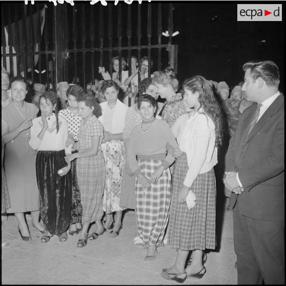 Des femmes regardent leurs voiles brûler, devant le gouvernement général.