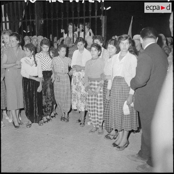 Des femmes regardent leurs voiles brûler, devant le gouvernement général.