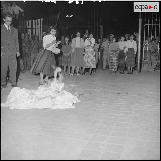 Des femmes brûlent leurs voiles, devant le gouvernement général.