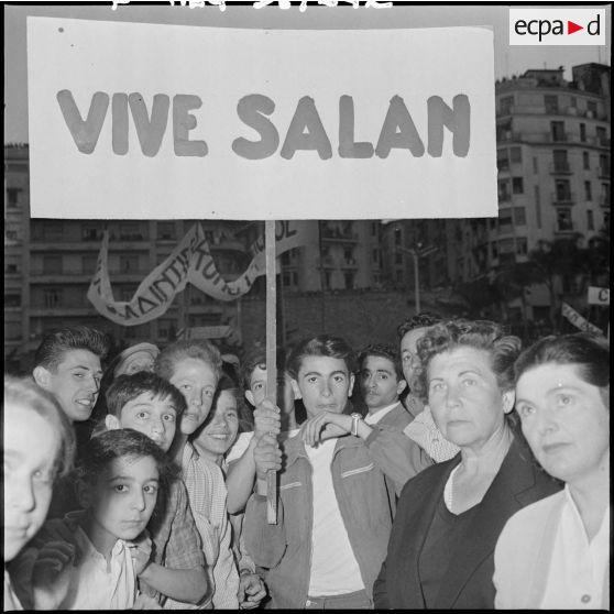 Un jeune manifestant brandit une pancarte portant l'inscription : "Vive Salan".