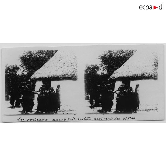 Les porteuses ayant fait toilette reçoivent des vivres. [légende d'origine]<br>