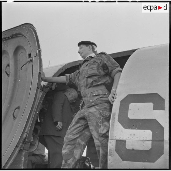 Un parachutiste dans l'encadrement de la porte d'un avion.
