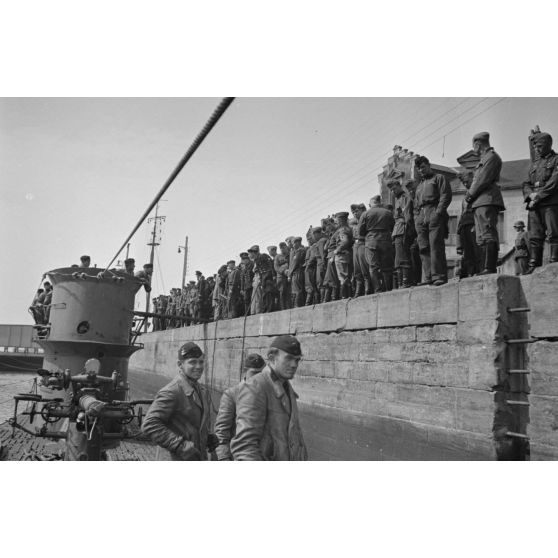 L'équipage du sous-marin U-553 quitte le navire sous les yeux du comité d'accueil composé de marins et d'aviateurs allemands.