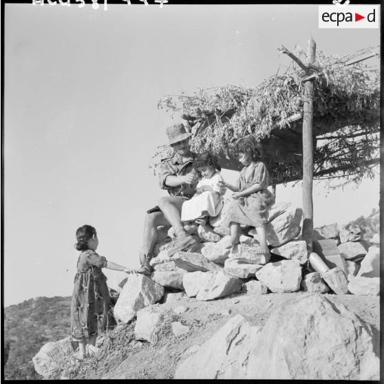 Tazerout. Les enfants tiennent compagnie aux parachutistes en sentinelle.