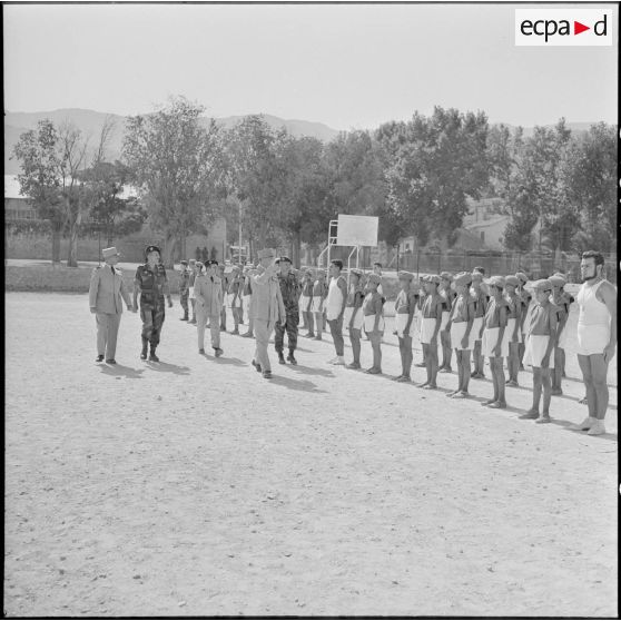 Des autorités militairs passent en revue ds jeunes sportifs.