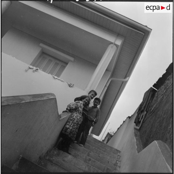 Des enfants devant une habitation.