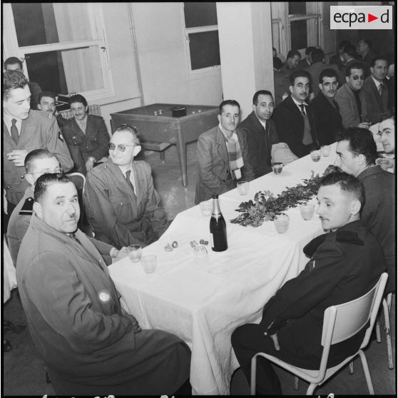 Un groupe d'hommes en compagnie d'officiers lors d'une réception.