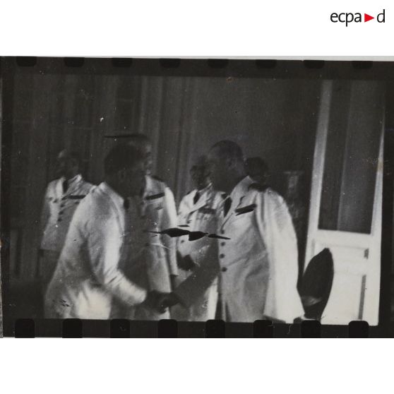 Dans le cadre de l'élection du président du gouvernement provisoire de la République Cochinchinoise, deux hommes se serrent la main. [description provisoire]