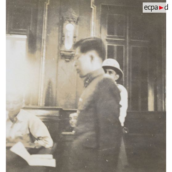 Lors du procès des criminels de guerre japonais, l'accusé, le lieutenant Tava, fait face aux juges. [description provisoire]