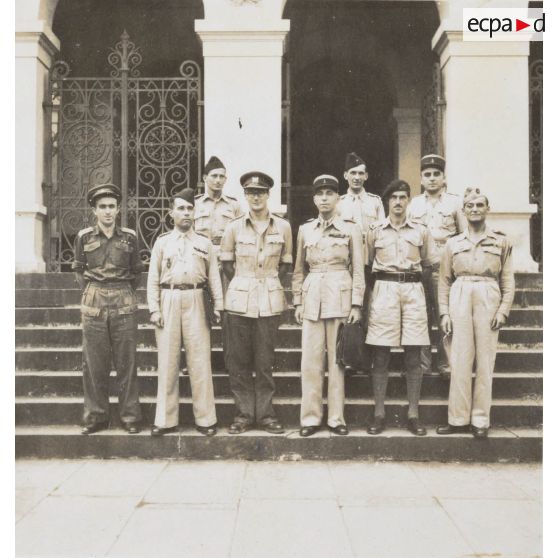 Devant le palais de justice, le lieutenant colonel Sompeyrac, président du tribunal militaire permanent de Saigon (au milieu) et le personnel de la cession du 23-12-46. [description provisoire]