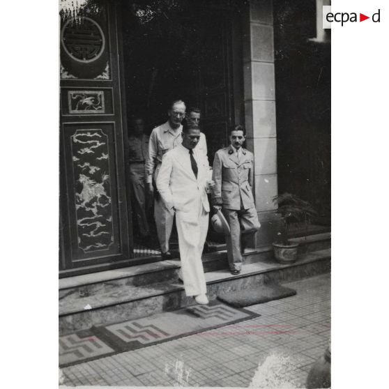 Accompagné d'autres personnalités, le président du gouvernement de la République de Cochinchine, Le Van Hoach, à la sortie d'un lieu.
