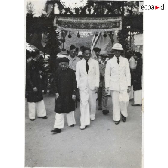 Dans le cadre de sa tournée à Gia Dinh et à Thu Duc, le président du gouvernement de la République de Cochinchine, Le Van Hoach, marche en compagnie d'autres personnes.