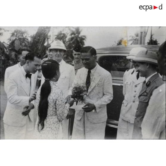 Une jeune fille offre des fleurs à Le Van Hoach, président du gouvernement de la République de Cochinchine, au cours d'une visite de celui-ci à Gia Dinh et à Thu Duc.