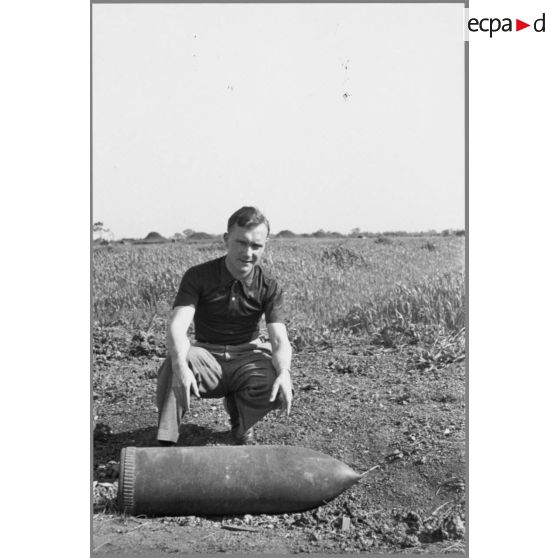 Robert Pila près d'un obus. [légende d'origine]