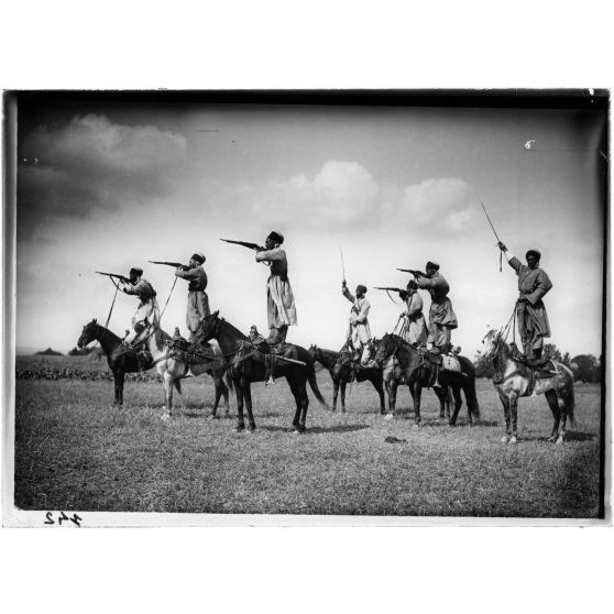 [Spahis debout sur leurs chevaux les armes à la main.]