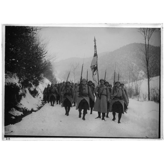 [Infanterie en marche armes et drapeau français à la main.]