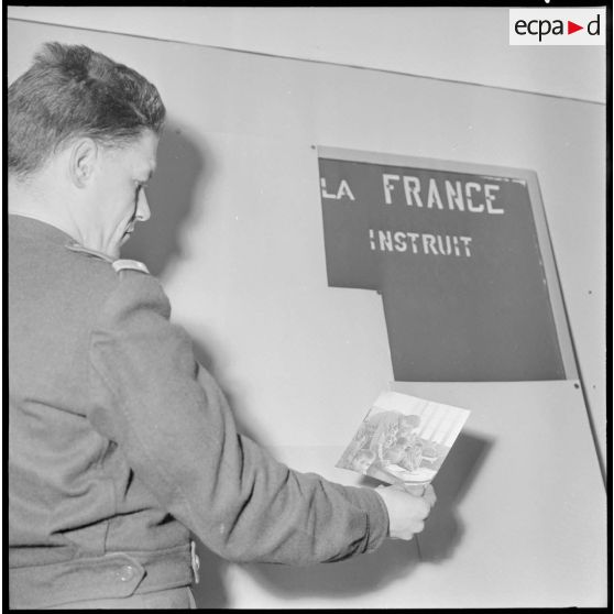 Algérie. 5e bureau. Un stagiaire officier regarde une photo pour la création d'une affiche de propagande.