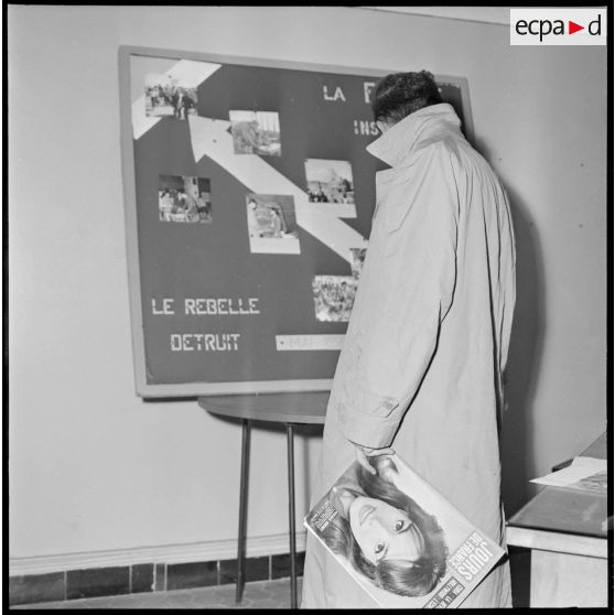 Algérie. 5e bureau. Un stagiaire officier regarde l'affiche de propagande terminée.