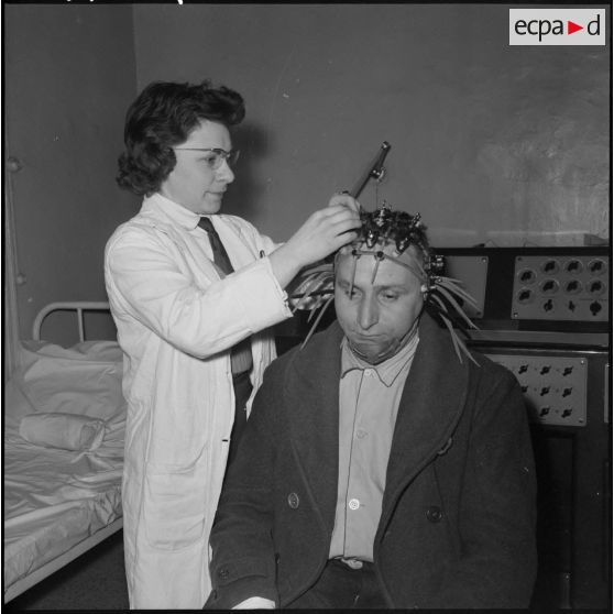Alger. Hôpital Maillot. Une infirmière pose des électrodes sur la tête d'un malade.