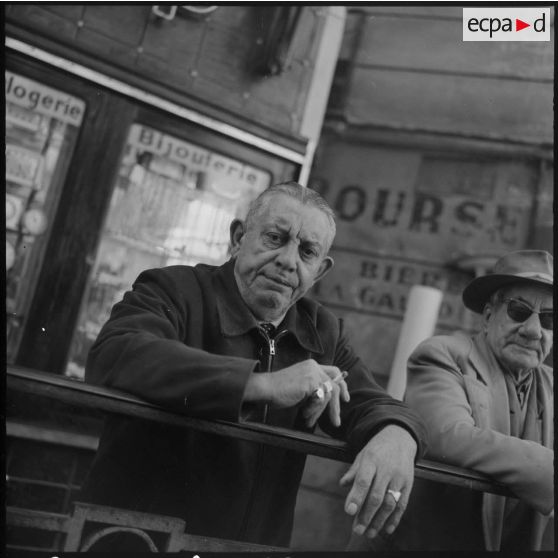 Alger. Quartier européen. Portrait de deux hommes devant une bijouterie horlogerie.
