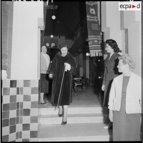 Alger. Centre d'apprentissage féminin. Nafissa Sid Cara sort de l'atelier des métiers à tisser.