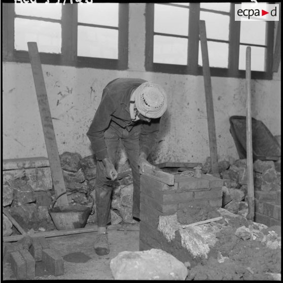 Oued Fodda. Un élève apprenti en maçonnerie apprend à monter un mur.