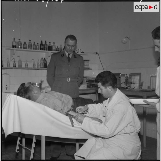 Une autorité rend visite à un soldat se faisant soigner à l'infirmerie du 9ème régiment de zouaves (RZ).