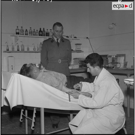 Une autorité rend visite à un soldat se faisant soigner à l'infirmerie du 9ème régiment de zouaves (RZ).