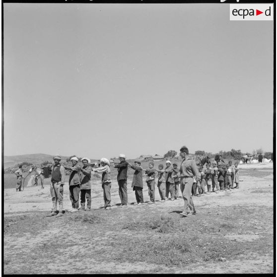 Le moniteur de la jeunesse rassemble les enfants de la bocca pour les faire jouer.