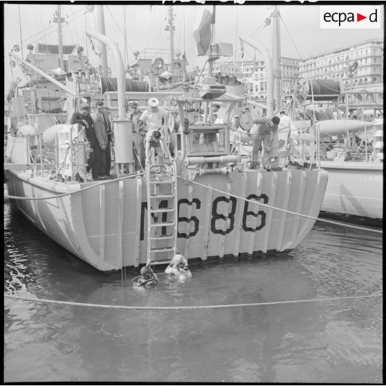 Deux plongeurs démineurs visitent la coque du "Marguerite" au retour de l'exercice.