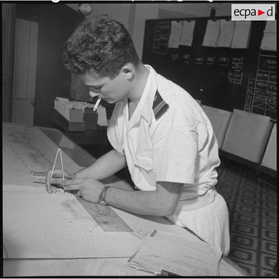 Sous le contrôle du capitaine de frégate Duval, l'officier de quart note sur la carte les renseignements que communiquent les dragueurs.