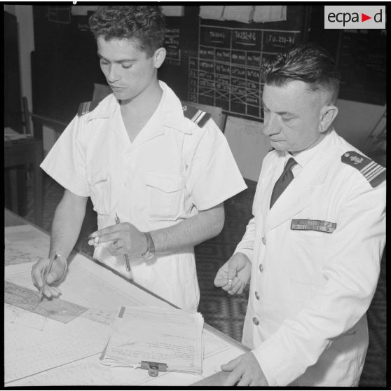 Sous le contrôle du capitaine de frégate Duval, l'officier de quart note sur la carte les renseignements que communiquent les drageurs.