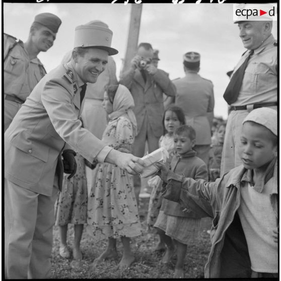 Sidi-Ghalem. Une autorité distribue un paquet à un enfant.