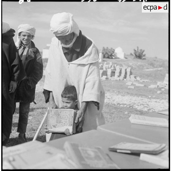 Sidi-Ghalem. Un petit garçon vient de recevoir son livre.