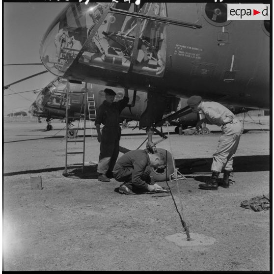 Setif - Aïn Arnat. Des militaires entretiennent un hélicoptère Piasecki  de la base héliport Maréchal de Lattre.